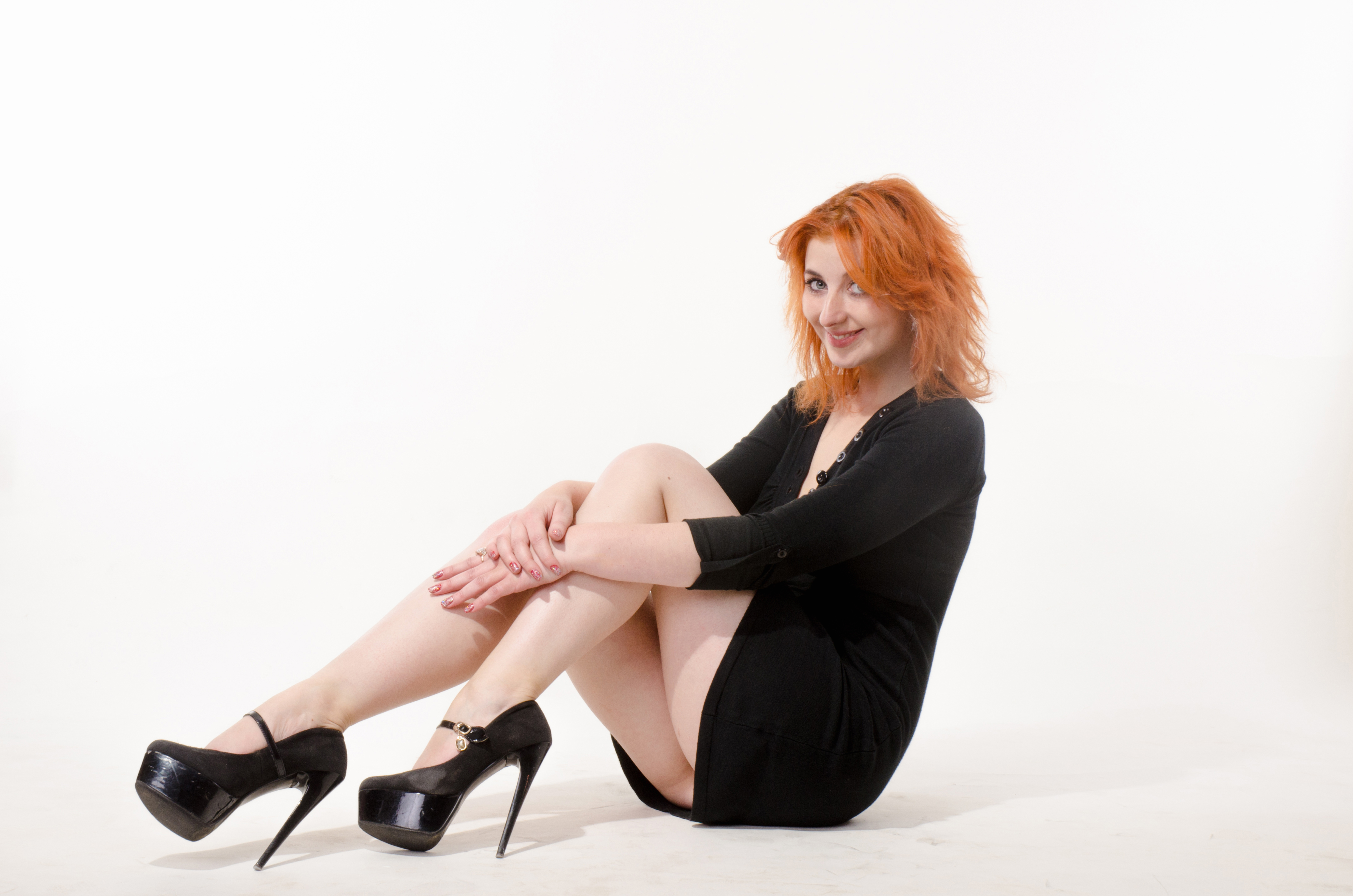 beautiful redhead girl in a black dress on a white background